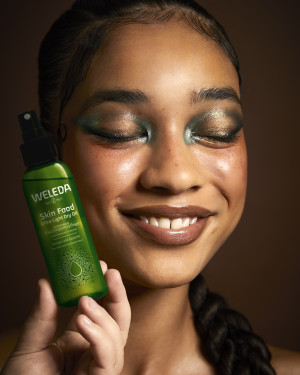 BIPOC Model hält das Weleda Dry-Oil als Heroprodukt der Weleda x The Face art academy Brand Kollaboration